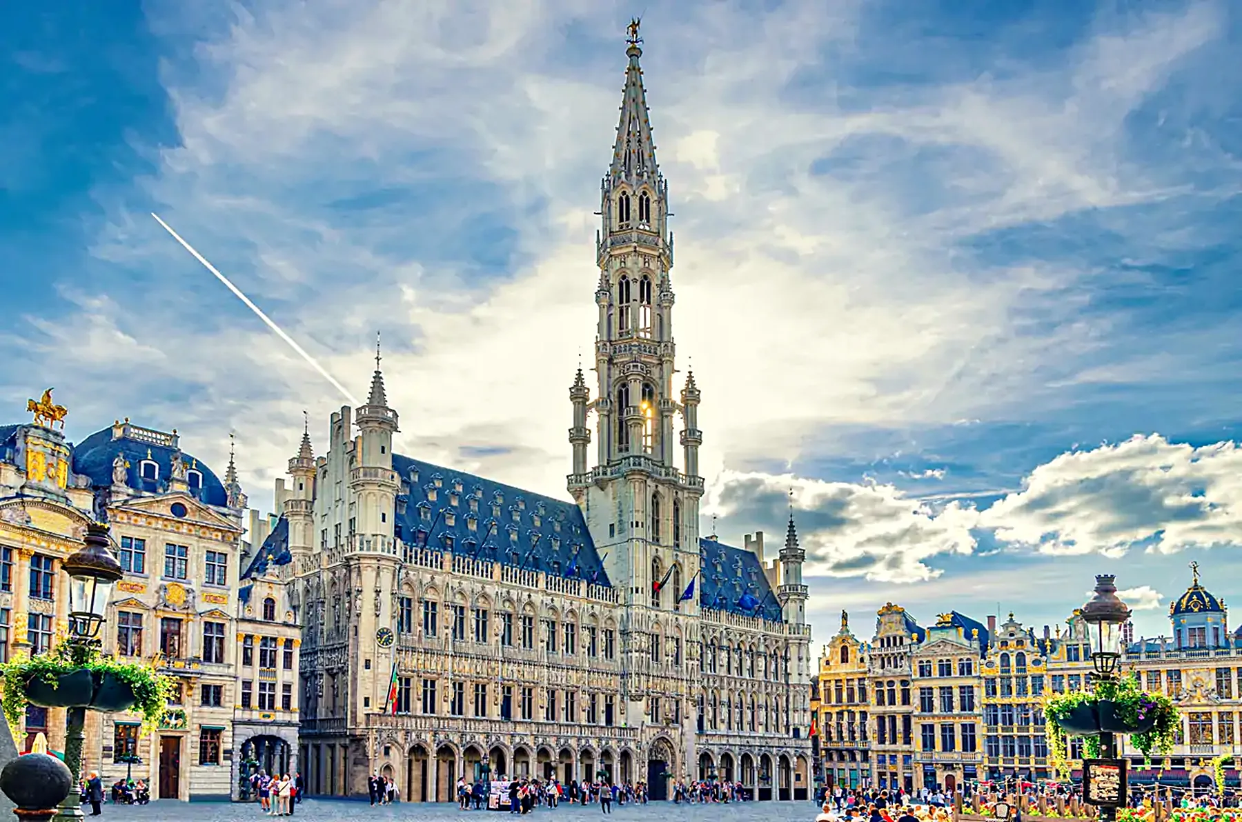 The Grand Place in Brussels — the Gothic Town Hall and its spire under a bright sky.